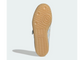 The outsole of a light blue and white sneaker, showing a textured tan rubber tread with circular grip patterns, photographed against a light gray background.